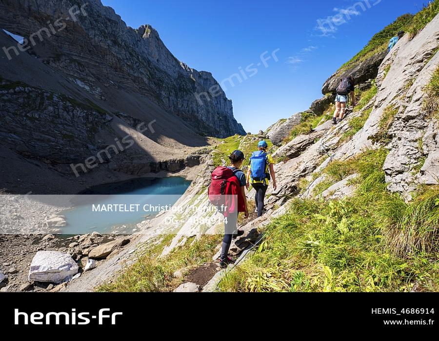 France, Haute-Savoie (74), Massif du Chablais, Montagnes du Giffre, Sixt-Fer-à-Cheval, réserve naturelle de Sixt-Fer-à-Cheval, randonneurs dans le court passage délicat qui surplombe le Lac des Chambres 