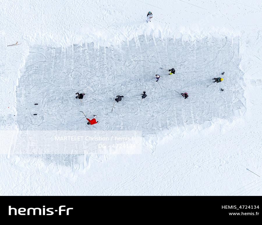 France, Hautes-Alpes (05), Briançon, Névache, la Vachette, partie de hockey dans un champ gelée (aerial view) 